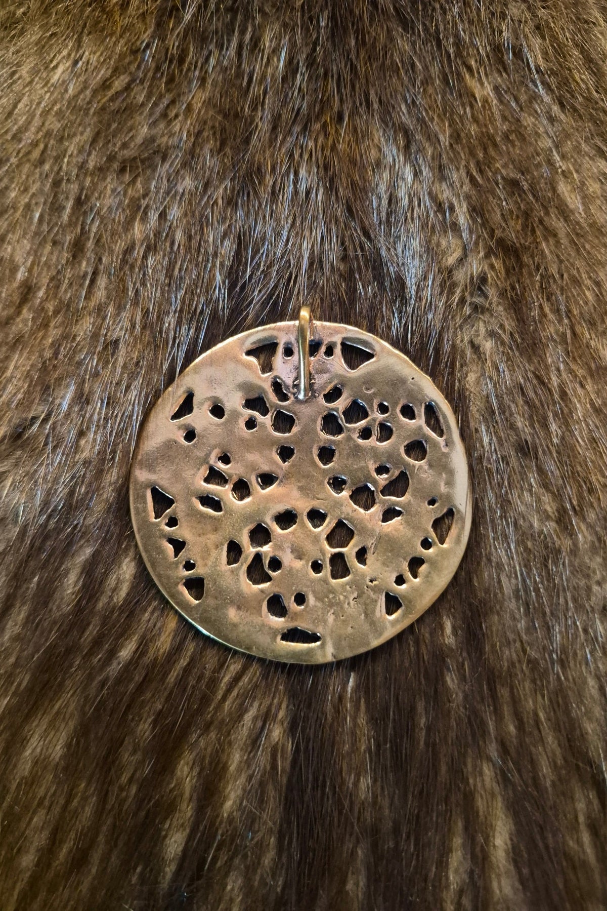 Rückseite des großen Wikinger Scheibenamulett im Borre-Stil aus Bronze mit der Öse zum befestigen an einer Kette oder Lederband.
