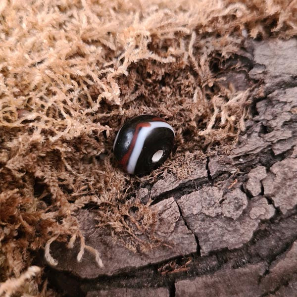 Small Viking disc bead, black with red and white thread pattern, made of glass