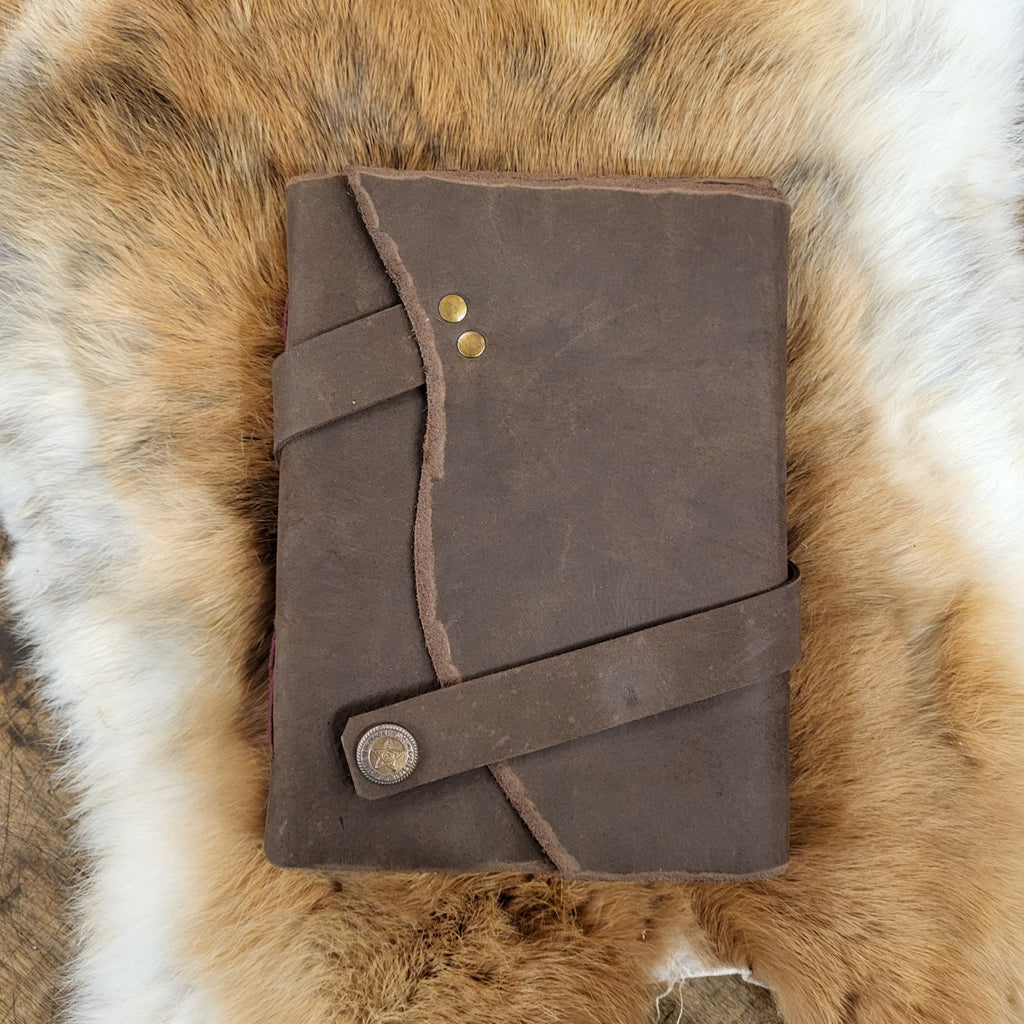 Notizbuch in Ledereinband und Lederriemen
