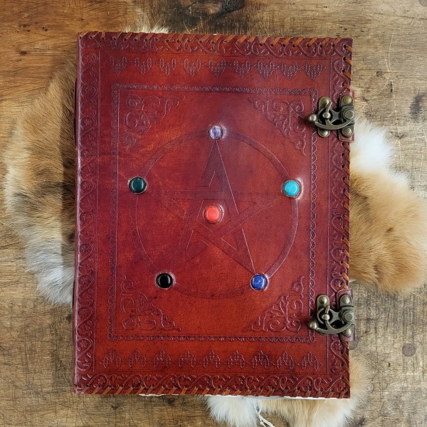 Riesiges Lederbuch mit geprägtem Pentagramm und sechs Steinen